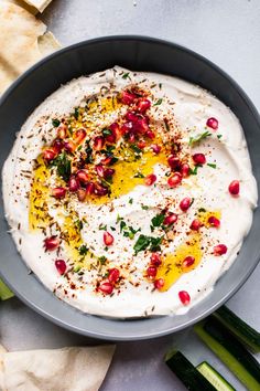 a bowl filled with hummus and garnished with herbs