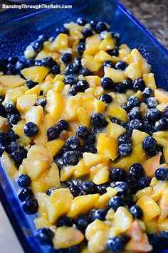 blueberries and peaches are mixed together in a casserole dish on the counter