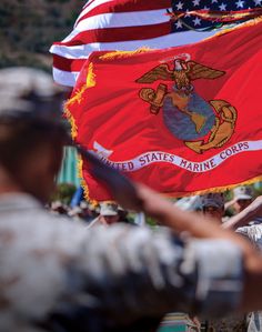 the marines flag is being held by two men