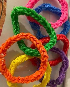 several different colored braided bracelets sitting on top of a white table next to each other