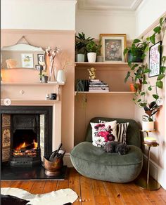 a living room filled with furniture and a fire place in front of a book shelf