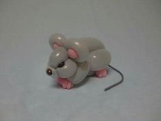 a small plastic mouse sitting on top of a white table next to a gray wall