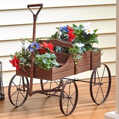 a wooden wagon filled with flowers on top of a hard wood floor