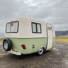 an old trailer is parked on the gravel