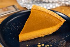 a slice of pumpkin pie on a black plate