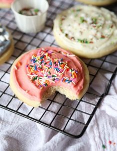 some cookies with icing and sprinkles on a cooling rack