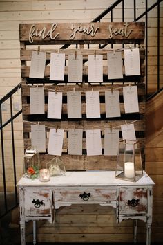 an old table with seating cards attached to it and some candles on top of it