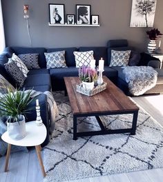 a living room with blue couches and pictures on the wall above them, along with a coffee table