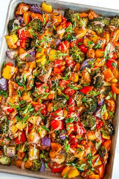 a casserole dish filled with vegetables on a white tablecloth and silver tray