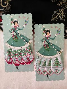 two christmas cards with an image of a woman in a green dress and bells on them