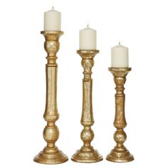 three golden candlesticks with white candles in them