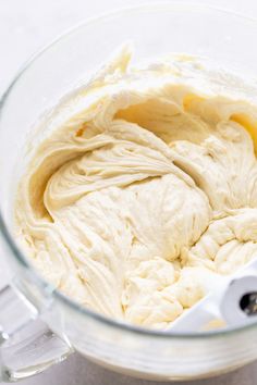 a mixing bowl filled with white batter on top of a counter