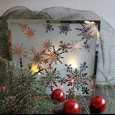 a christmas card with snowflakes on it and red baubles in the foreground