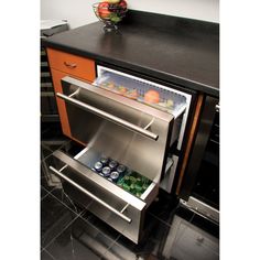 an open dishwasher sitting on top of a counter next to a bowl of fruit