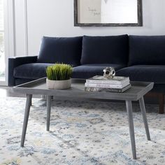 a living room with a blue couch, coffee table and books on the end tables