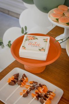 an orange plate topped with cake pops and marshmallows