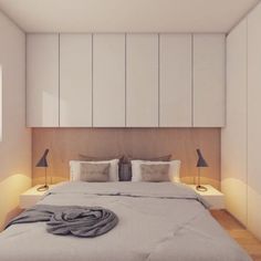 a bed sitting in a bedroom next to two lamps on either side of the headboard