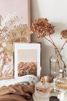 an arrangement of flowers and other items on a table in front of a framed photograph