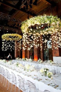 an image of a wedding setup with flowers and greenery hanging from the ceiling,