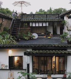 an outside view of a house with plants on the roof and stairs leading up to it