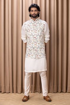 Off white nehru jacket with floral hand painted digital prints.
Component: 1
Pattern: Digital Print
Type Of Work: Floral Patterns
Neckline: Mandarin Collar
Sleeve Type: Sleeveless
Fabric: Cotton Silk, Lining: Twill Satin
Color: Off White
Other Details: 
Note: Kurta and pant worn by the model is not for sale
Occasion: Sangeet - Aza Fashions White Fitted Nehru Jacket For Spring, White Embroidered Nehru Jacket For Spring, White Embroidered Bandhgala For Spring, Spring White Embroidered Nehru Jacket, Spring Embroidered White Nehru Jacket, White Digital Print Kurta For Eid, White Designer Kurta For Spring, Spring Designer White Kurta, White Nehru Jacket With Floral Embroidery For Spring