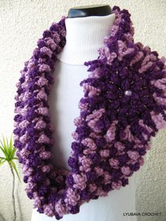 a purple and white crocheted scarf on a mannequin