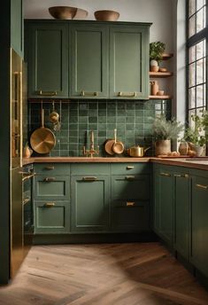 a kitchen with green cabinets and gold pots on the counter top, along with wooden flooring