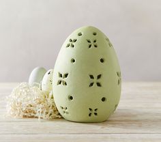 an egg with holes in it sitting next to some shredded white material on a table