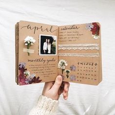 a hand holding an open calendar with flowers on it