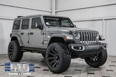 a gray jeep is parked in a garage