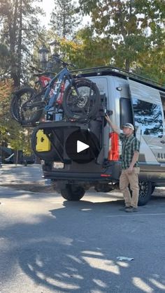 a man standing next to a van with bicycles on it