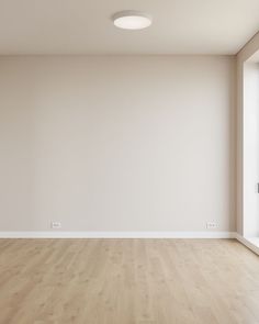 an empty room with white walls and wooden floors is shown in this image, there are no people or objects on the floor