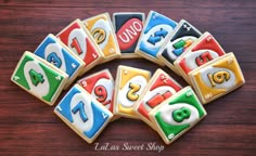 cookies decorated with letters and numbers are arranged in the shape of a circle on a wooden table