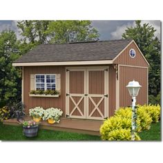 a garden shed is shown with flowers in the front yard and on the outside side