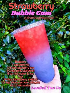 a hand holding up a purple and red drink in front of some bushes with the words strawberry bubble gum on it