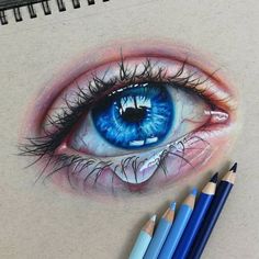 a drawing of an eye with colored pencils next to it