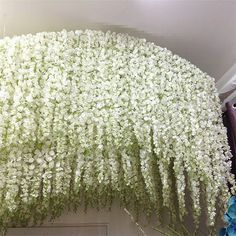 white flowers hanging from the side of a building