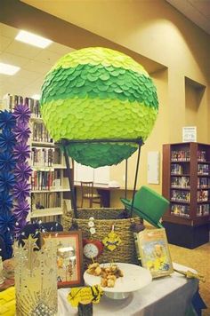 a table topped with lots of different types of food and drinks next to bookshelves