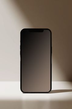 an iphone is sitting on a table with the shadow from it's back end