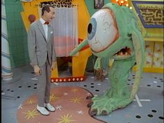 a man in a suit standing next to a fake creature