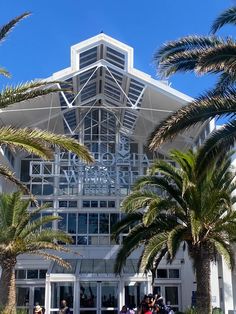 palm trees and people walking in front of a building