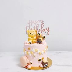 a pink birthday cake with two teddy bears on top