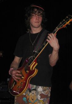 a young man is playing an electric guitar