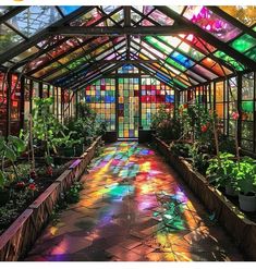 the inside of a glass house with lots of potted plants and flowers in it