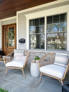 two wicker chairs sitting on the front porch