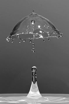 an umbrella that is upside down in the water with drops of water coming out of it