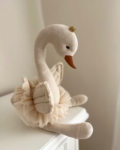 a stuffed swan sitting on top of a dresser