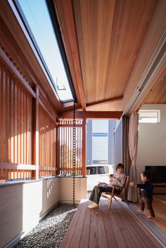 a woman sitting in a chair on top of a wooden floor next to a child