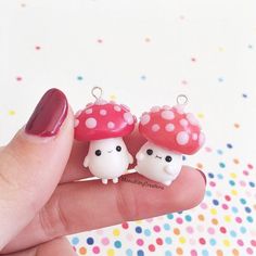 two tiny mushrooms sitting on top of each other in front of a person's hand