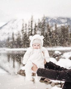 a person holding a baby in the snow